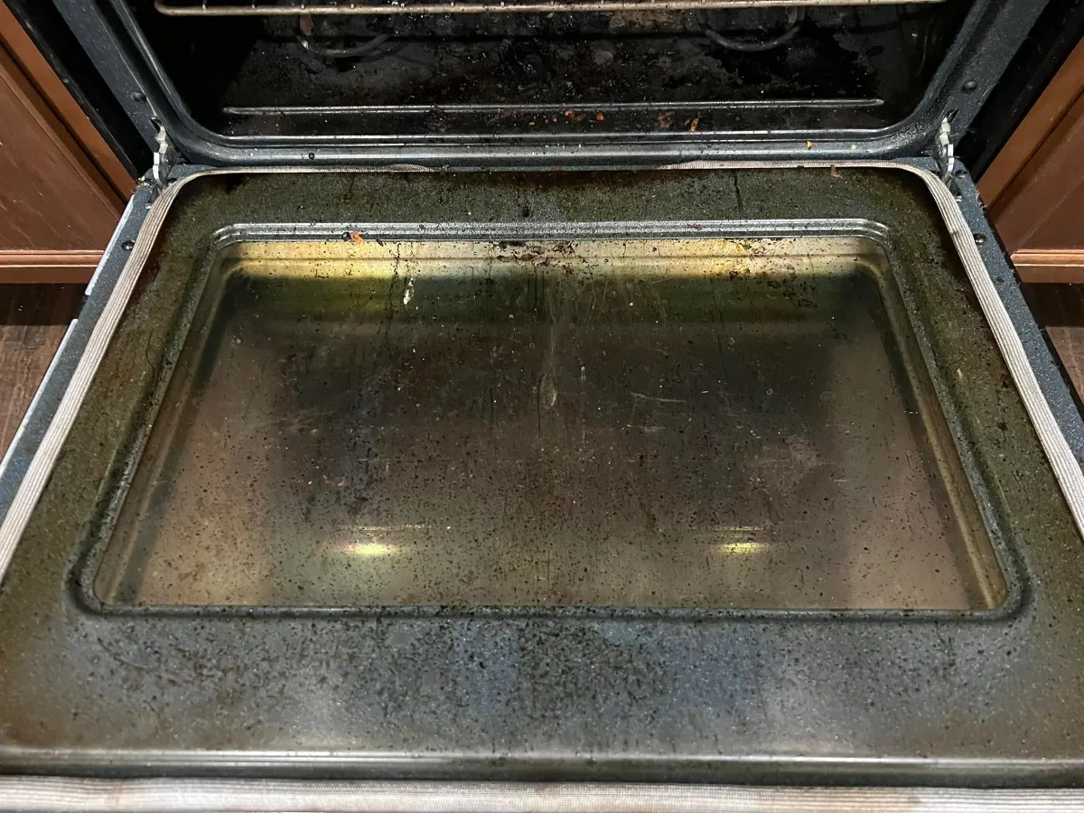 Before: oven door glass coated in grease