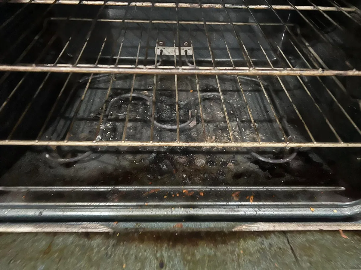 Before: oven floor caked with burnt-on grease